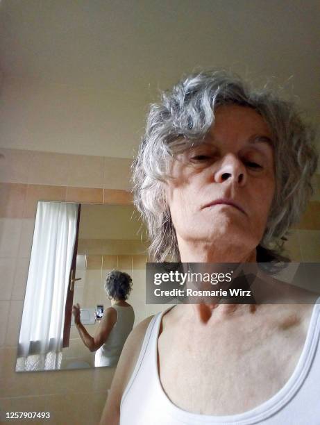 selfie of senior woman reflected in bathroom mirror - woman gray hair mirror stock pictures, royalty-free photos & images