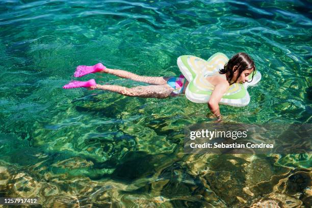 beautiful girl floats and falls asleep on the beach in jelsa, croatia, europe. - croatia girls stock pictures, royalty-free photos & images