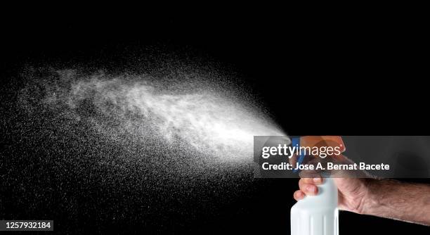 close-up of person  wearing glove to disinfect and clean sprayed with a disinfectant spray bottle. - covid particle stock pictures, royalty-free photos & images