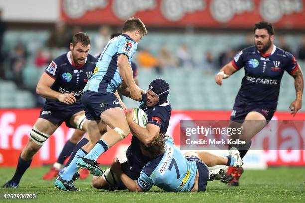 Michael Wells of the Rebels is tackled by Alex Newsome of the Waratahs during the round 4 Super Rugby AU match between the NSW Waratahs and the...