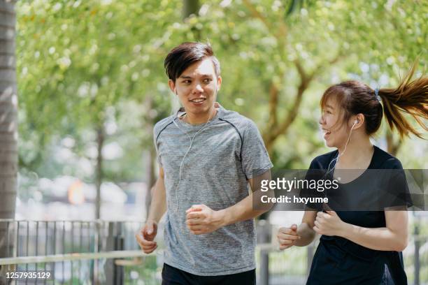 精力充沛的年輕夫婦早上一起在城市公園慢跑。 - hong kong community 個照片及圖片檔