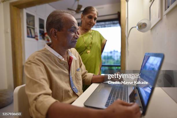 senior couple shopping online using card - indian elderly couple stock pictures, royalty-free photos & images