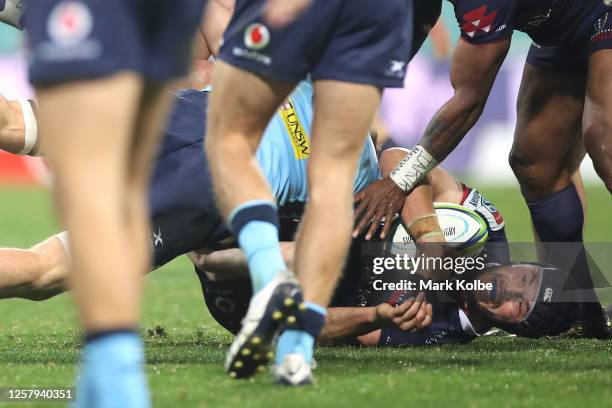 Michael Wells of the Rebels is tackled by Alex Newsome of the Waratahs during the round 4 Super Rugby AU match between the NSW Waratahs and the...