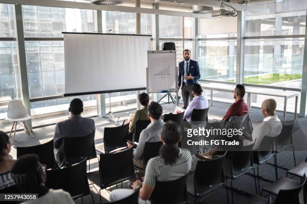 uomini d'affari che partecipano a un seminario con distanziamento sociale - conferenza stampa foto e immagini stock