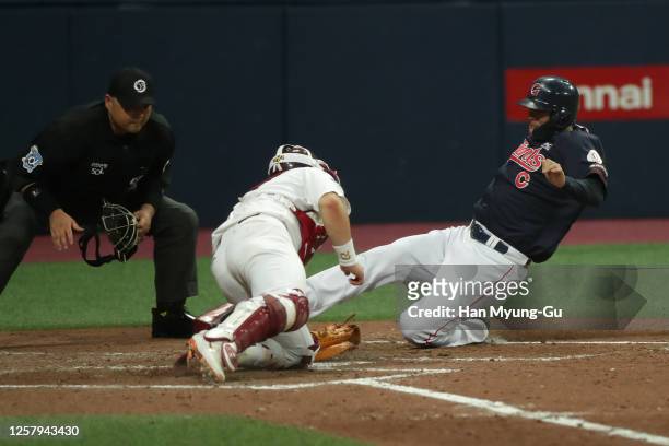 Outfielder Min Byung-Hun of Lotte Giants slides safely into the home plate to make the score 4-2 in the top of fourth inning during the KBO League...
