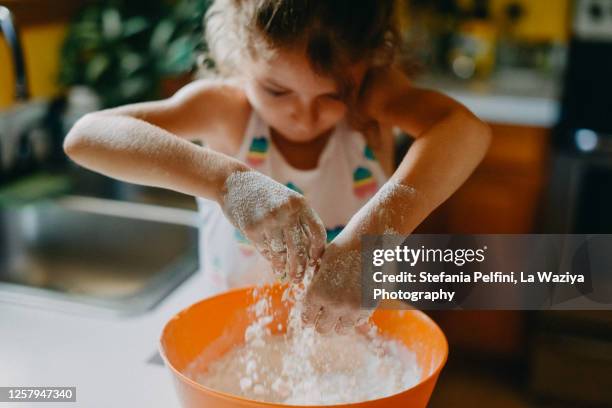 little girl sensory experiences flour while baking bread - flour stock pictures, royalty-free photos & images