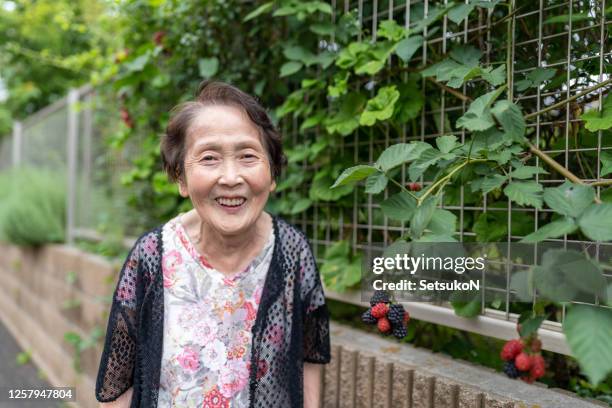 happy asian senior woman smiling, outside - psychiatric ward stock pictures, royalty-free photos & images