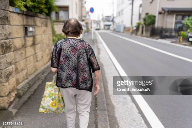 asian senior woman going for shopping - senior women walking stock pictures, royalty-free photos & images