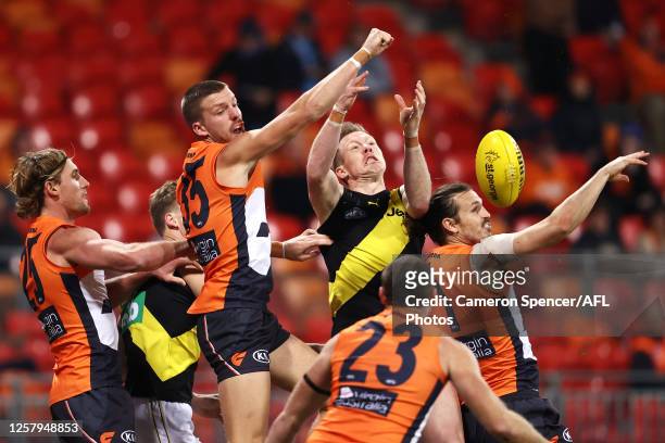 Harry Perryman of the Giants, Jack Riewoldt of the Tigers, and Phil Davis of the Giants contest the ball during the round 8 AFL match between the...