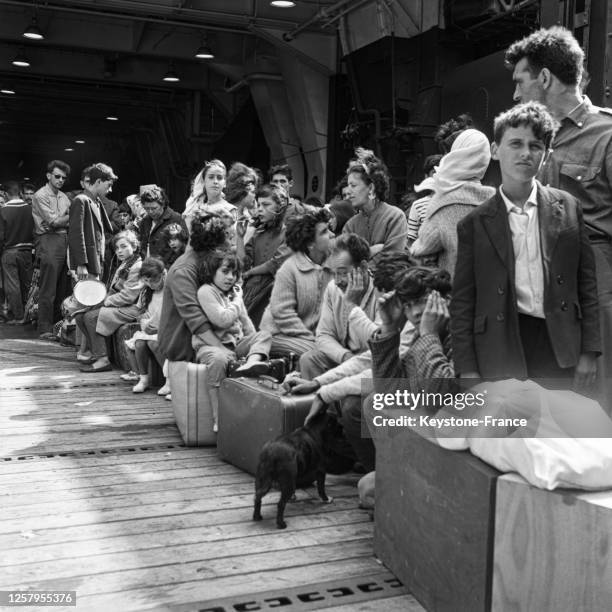 Rapatriés d'Algérie, attendant sur le pont d'un bateau, arrivés à Marseille, France, en 1962. De la signature des Accords d'Evian à la proclamation...