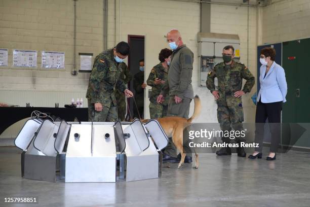 German Defence Minister Annegret Kramp-Karrenbauer looks on as a member of the Bundeswehr, the German armed forces, leads a dog to a test device that...