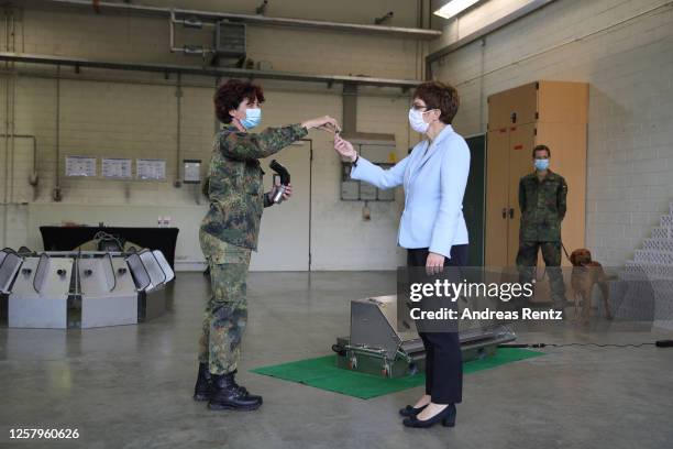 German Defence Minister Annegret Kramp-Karrenbauer examines a covid test vial offered by Doctor Schalke as a member of the Bundeswehr, the German...