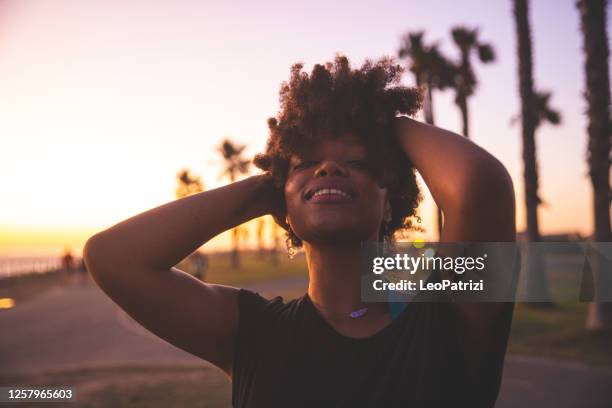 woman enjoying the last sun of the day on a beach in california - african american women in the wind stock pictures, royalty-free photos & images