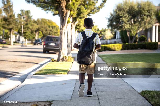 young little boy walks to school in the morning - walking boy school stock pictures, royalty-free photos & images