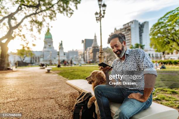 senior latino man walking his senior retriever dog - old phone imagens e fotografias de stock