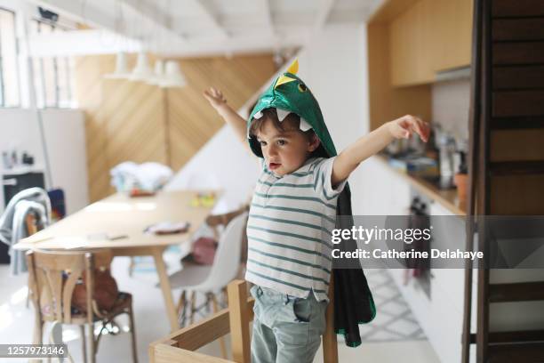 a little boy dressed as a dinosaur playing in the kitchen - france costume stock pictures, royalty-free photos & images