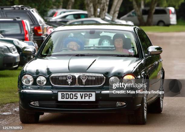 Queen Elizabeth II drives herself in her Daimler Jaguar car to The Credit Suisse Royal Windsor Cup Final at Guards Polo Club, Smith's Lawn on June...