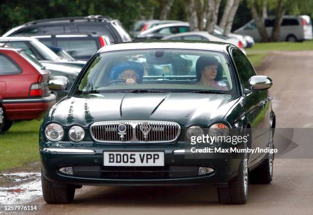 Queen Elizabeth II drives herself in her Daimler Jaguar car to The Credit Suisse Royal Windsor Cup Final at Guards Polo Club, Smith's Lawn on June...