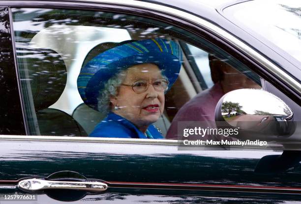 Queen Elizabeth II drives herself in her Daimler Jaguar car to The Credit Suisse Royal Windsor Cup Final at Guards Polo Club, Smith's Lawn on June...