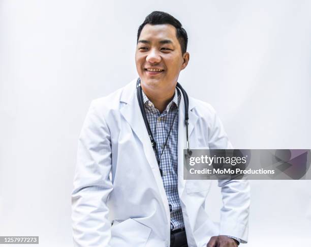 studio portrait of doctor/healthcare worker - portrait white background looking away stockfoto's en -beelden