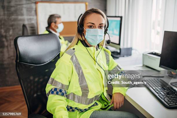 young female police officer working in police office - funcionário público imagens e fotografias de stock