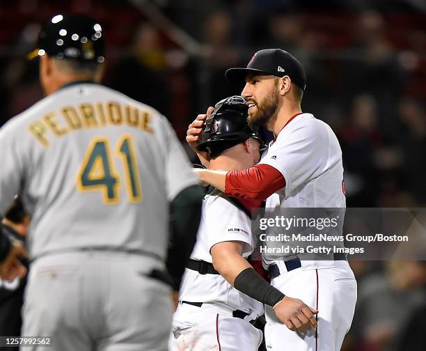 Boston Red Sox catcher Christian Vazquez, left, and relief pitcher Matt Barnes hug as they celebrate their 9-4 win over the Oakland Athletics after a...