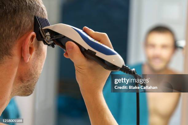 person cutting own hair at home during quarantine - nagelklippare bildbanksfoton och bilder