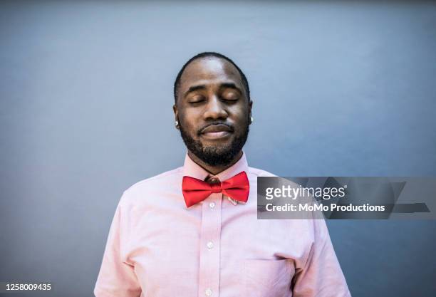 studio portrait of man wearing red bow tie - bow tie stock pictures, royalty-free photos & images