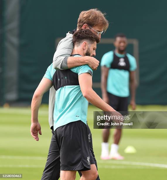 Jurgen Klopp manager of Liverpool with Adam Lallana of Liverpool during a training session at Melwood Training Ground on July 24, 2020 in Liverpool,...