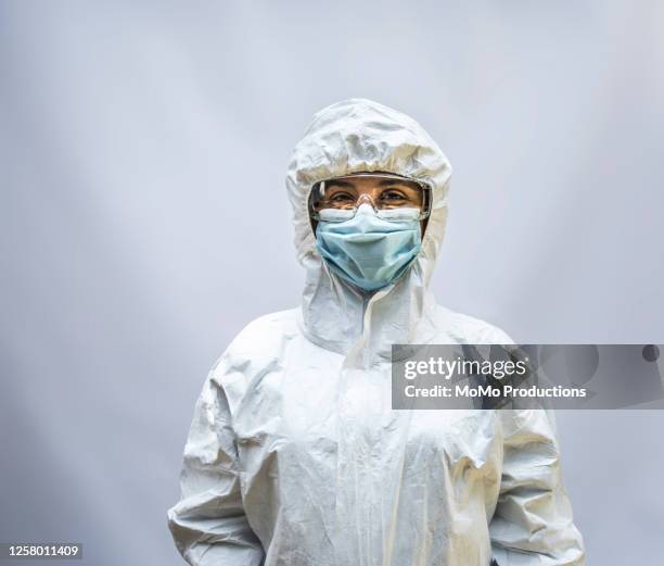 studio portrait of healthcare worker in biohazard suit - biohazard symbol stockfoto's en -beelden