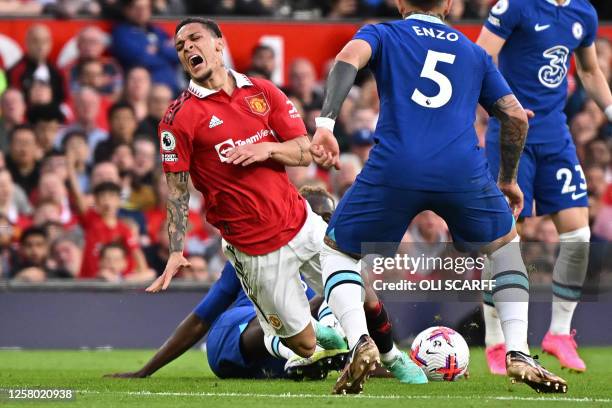 Manchester United's Brazilian midfielder Antony is hurt in this challenge with Chelsea's English defender Trevoh Chalobah during the English Premier...