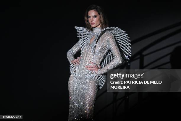 Brazilian model Alessandra Ambrosio presents an outfit auctioned off during the annual amfAR Cinema Against AIDS Cannes Gala at the Hotel du...