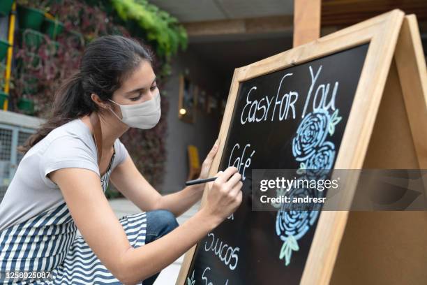 waitress wearing a facemask while writing the menu at a restaurant - covid cafe menu stock pictures, royalty-free photos & images