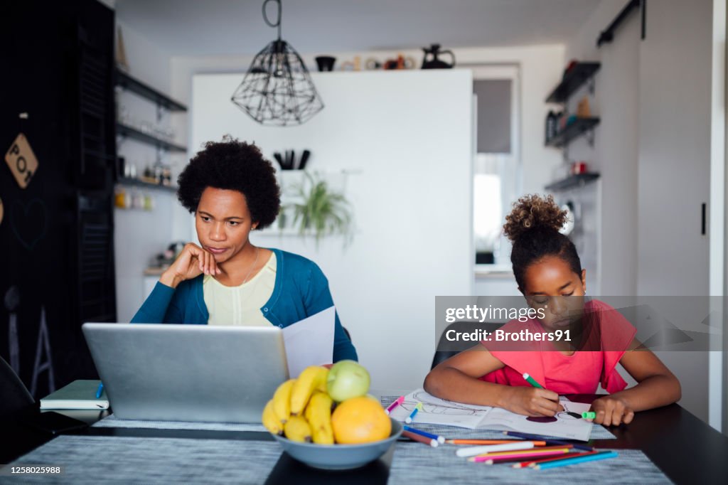 An African American mother homeschooling her daughter at home