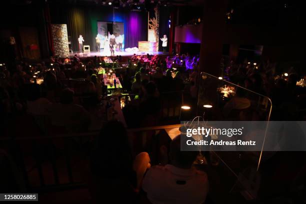 Guests sit separated from each other by a protective spit panel at a table during the theatre play "Beethovens verschollenes Werk" at GOP Varieté...