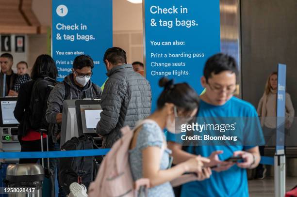 Travelers at a check-in kiosk at San Francisco International Airport in San Francisco, California, US, on Thursday, May 25, 2023. Long airport lines,...