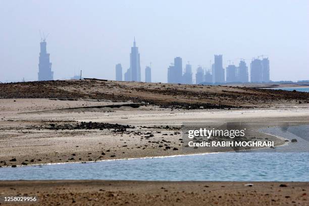 The Dubai Marina stands behind the islands of "The World," 4kms off the coast of Dubai, 31 October 2006. "The World," due to be finished end of 2008,...