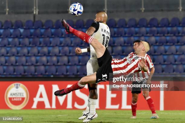 Tacuary's midfielder Victor Ayala fights for the ball with Estudiantes de La Plata's forward Mauro Boselli during the Copa Sudamericana group stage...