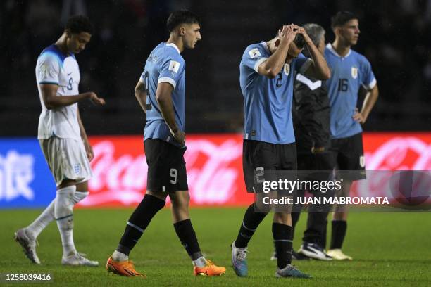 Uruguay's defender Sebastian Boselli forward Andres Ferrari , and defender Facundo Gonzalez, gesture after loosing 3-2 against England during the...