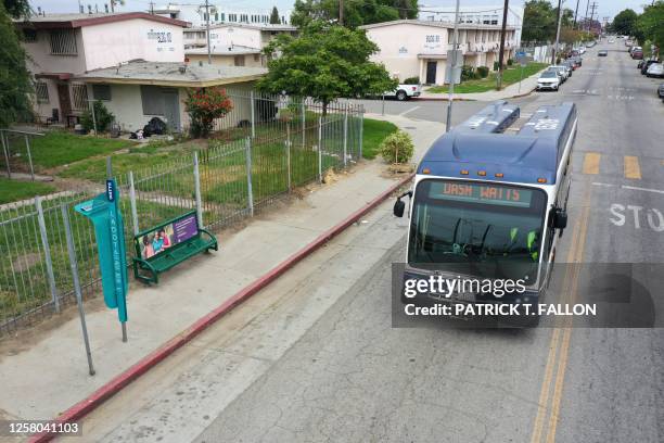 An DASH bus drives past La Sombrita, a prototype bus stop structure to provide shade during the day and solar-powered lighting at night installed by...
