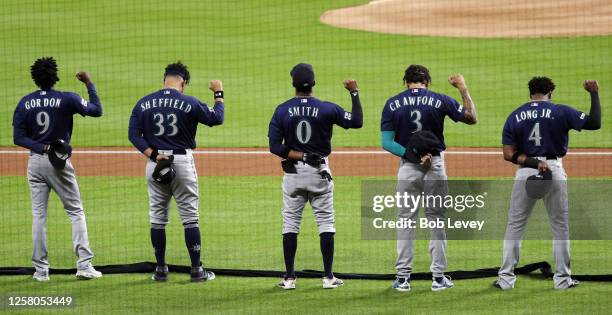 Dee Gordon, Justus Sheffield, Mallex Smith, J.P. Crawford and Shed Long Jr. #4 of the Seattle Mariners raise their fist during the national anthem...