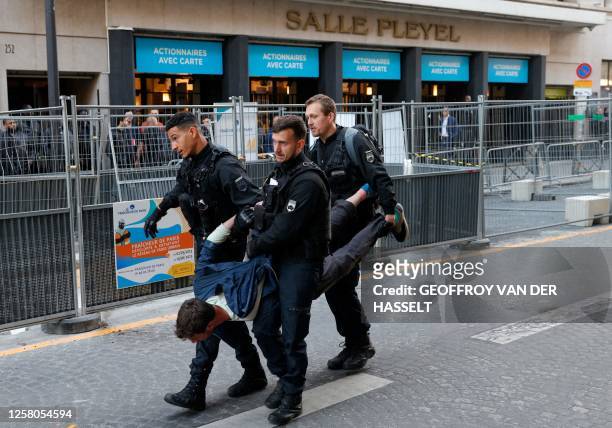 French gendarmes evacuate a climate protester as they walk past Salle Pleyel during a demonstration on the outskirts of the Paris venue for...