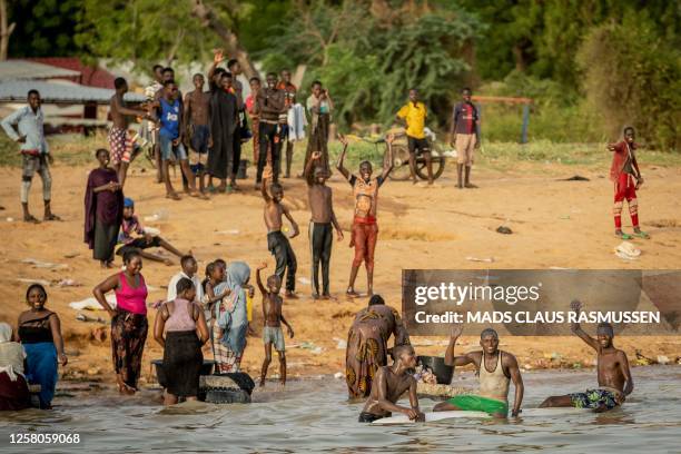 Wellwishers greet Denmark's Crown Prince and Minister for Development Cooperation and Global Climate Policy during a boat trip on the Niger River in...