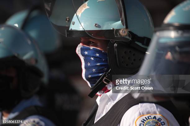 Police stand guard at the Homan Square police station while activists hold a rally across the street calling for the defunding of police on July 24,...