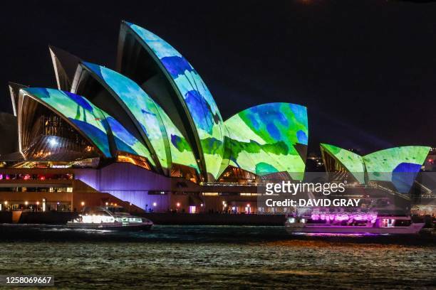 The Sydney Opera House and boats are illuminated with projections and lights at the start of the Vivid Sydney festival in Sydney on May 26, 2023.