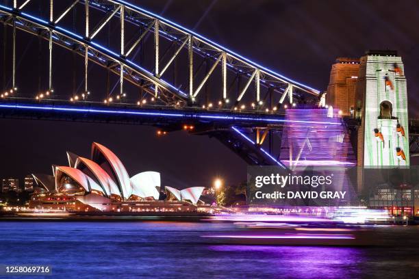 The Sydney Opera House, Sydney Harbour Bridge and boats are illuminated with projections and lights at the start of the Vivid Sydney festival in...