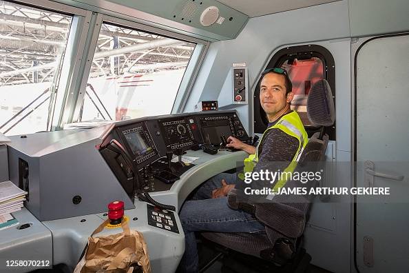 A train driver poses in the cabin of an European Sleeper night train ...