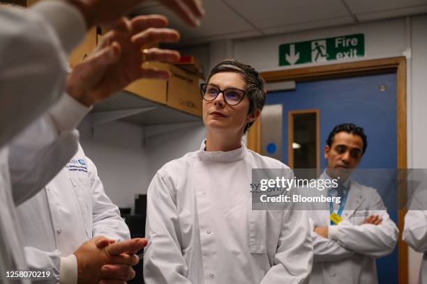 Chloe Smith, acting UK science, innovation and technology secretary, center, talks with researchers inside a laboratory, using equipment manufactured...