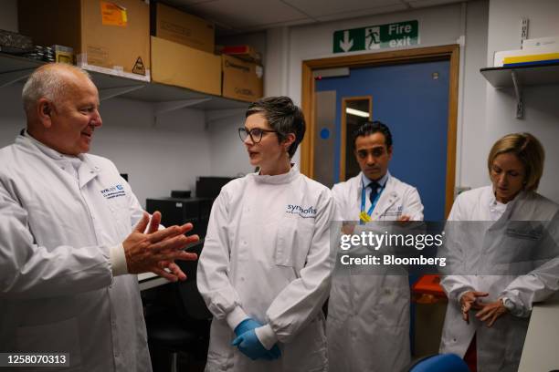 Chloe Smith, acting UK science, innovation and technology secretary, center, talks with researchers inside a laboratory, using equipment manufactured...