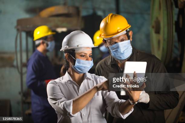 colleghi di lavoro che utilizzano tablet digitale in fabbrica - lavoro e impiego foto e immagini stock